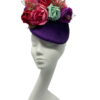 Purple velvet headpiece with an array of various coloured flowers.